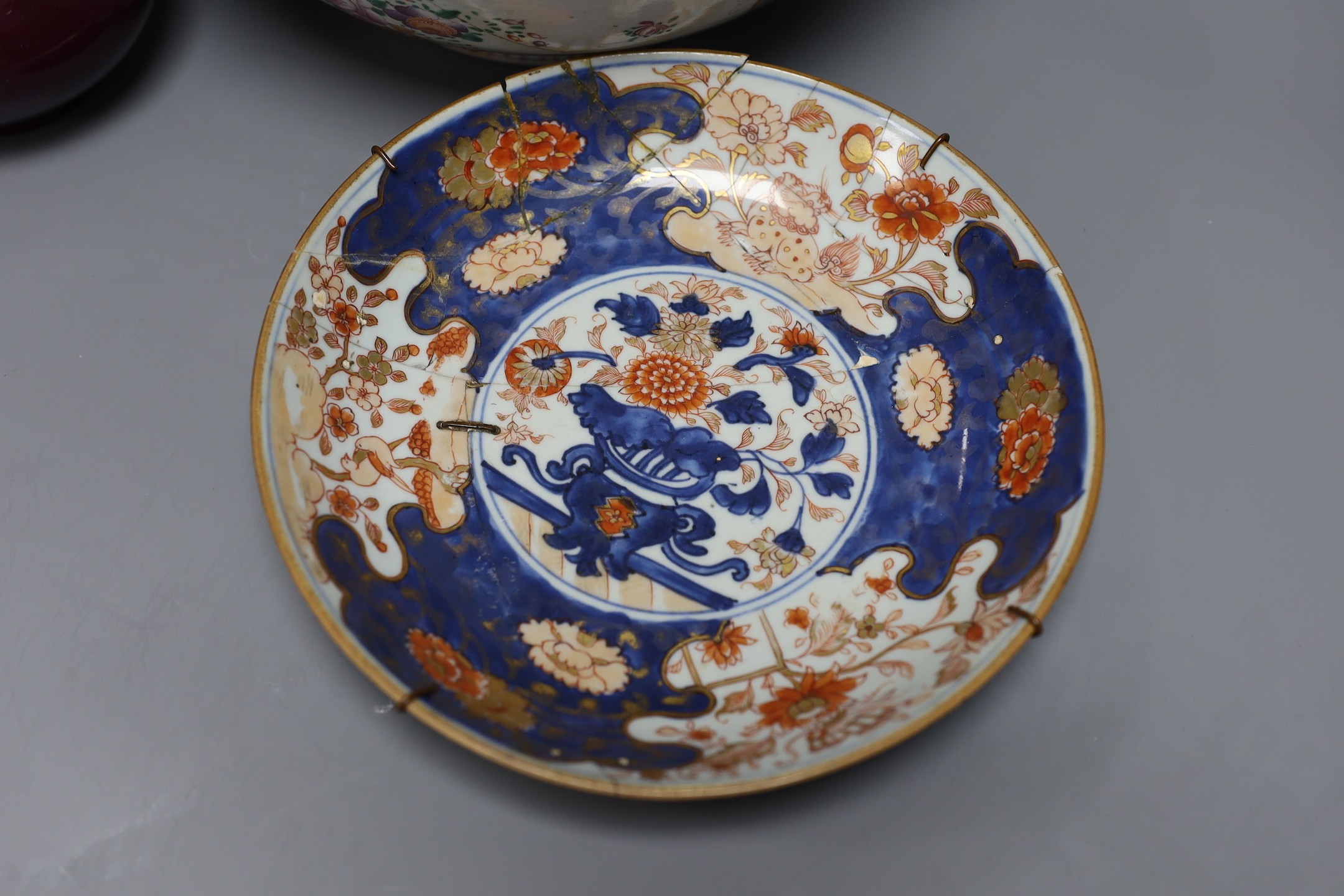 An 18th century Japanese Imari dish (af), another Imari dish, an 18th century Chinese export bowl (af) and a Chinese sang de boeuf vase, diameter of largest bowl 29cm